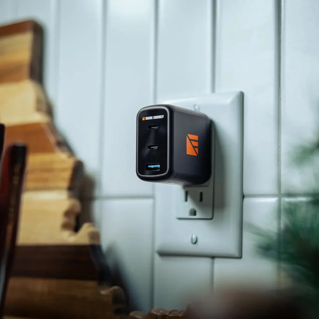 The Dark Energy 65W wall charger plugged into a wall outlet.