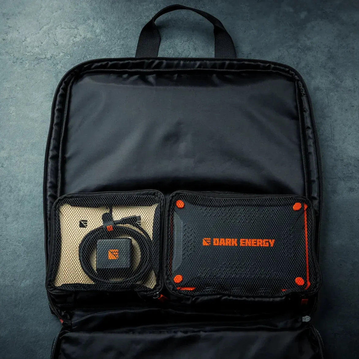 The Dark Energy charger stored in an open tech organiser pouch.