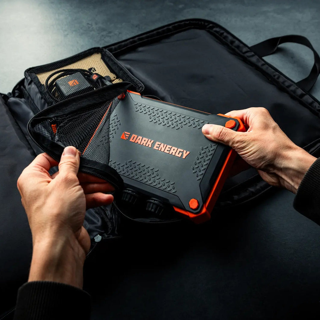Hands placing a Poseidon power bank into the Spectre accessories case.