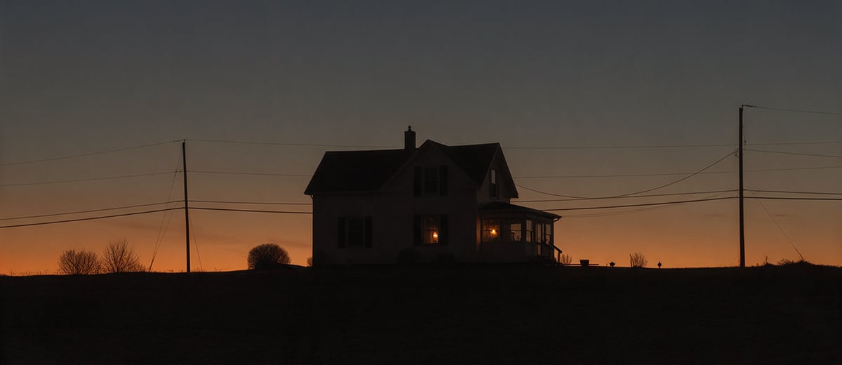 A farmhouse on a ridge at dusk during a power outage, one window lit by a lantern